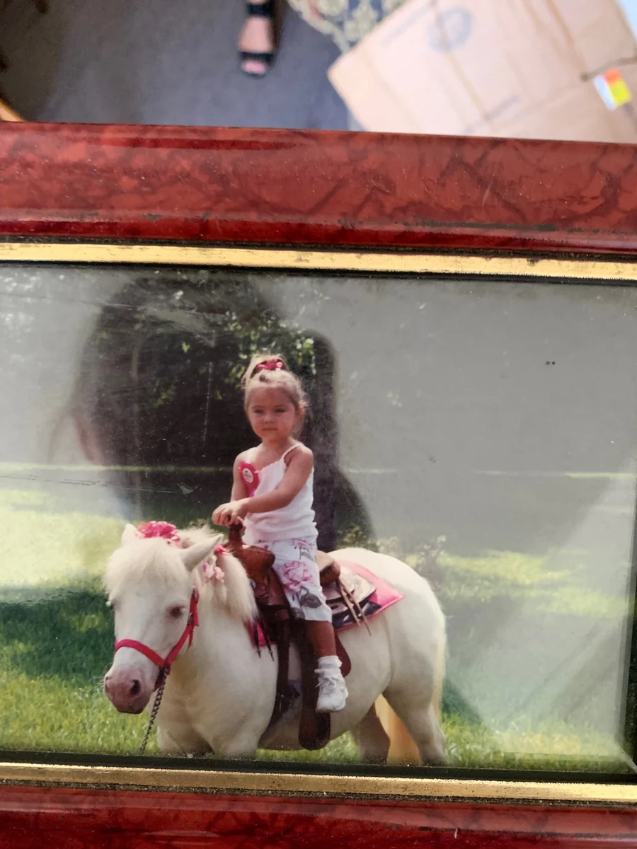 A family photo of Iva as a young child riding a white pony